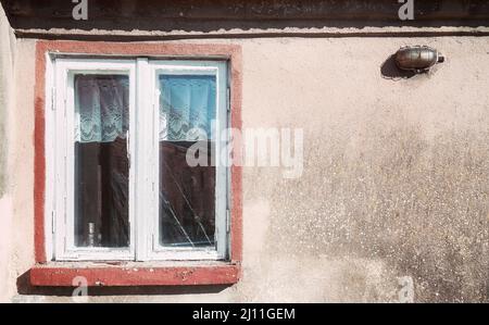 Ancienne fenêtre en bois dans un bâtiment aux intempéries, couleurs appliquées. Banque D'Images