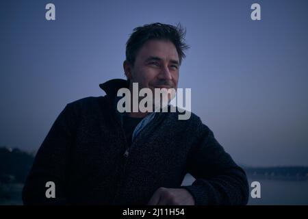 Portrait de l'homme adulte moyen devant le paysage nordique froid. Portrait d'âge mûr, d'âge moyen, d'homme adulte moyen en 50s, sourire heureux. Banque D'Images