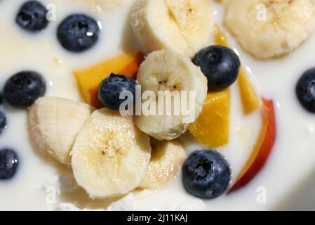 Yaourt blanc aux fruits frais - pêche, mangue, bleuets, bananes. Produit acide Banque D'Images