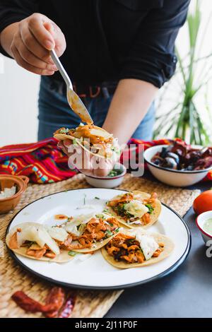 Femme mexicaine mains préparant tacos al pasteur avec sauce. Cuisine traditionnelle au Mexique Amérique latine Banque D'Images