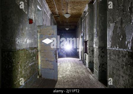 Couloir à l'intérieur d'un asile abandonné avec éclairage moody. Banque D'Images