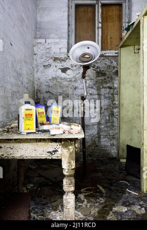 Moulages dentaires, produits chimiques à rayons X, prothèses dentaires et une vieille lampe dentaire à l'intérieur du sous-sol d'un asile abandonné. Banque D'Images