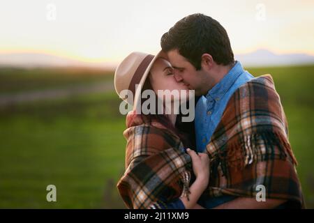 Les deux ont trouvé des soulmates l'un dans l'autre. Photo d'un jeune couple affectueux partageant un baiser. Banque D'Images