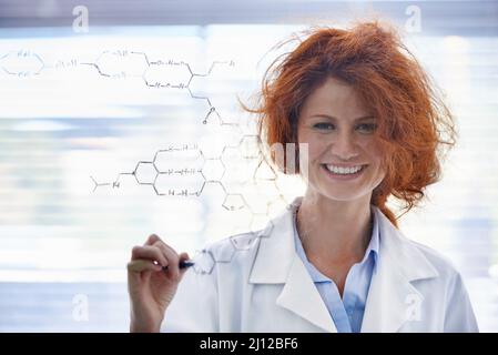 La chimie organique a été couverte. Une scientifique aux cheveux salissants debout dans son laboratoire fièrement. Banque D'Images