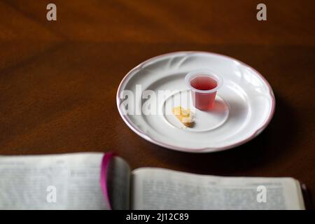 Sacrements de la Sainte Communion chrétienne, vin et pain avec la Sainte Bible ouverte, sur une table en bois. Banque D'Images