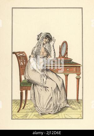 Mode féminin, époque révolutionnaire française, Paris, 1800. Femme dans une robe basse faisant un voile de dentelle dans une coiffure, assise devant un miroir à une coiffeuse. Coeffure forgée d'un voile... Le Journal des Dames et des modes, an VIII, costumes parisiens 236. Lithographie pochorale de couleur main de Marcel Bry, de Raymonde See’s le Costume de la Révolution a nos jours, Editions de la Gazette des Beaux-Arts, Paris, 1929. Banque D'Images