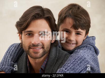 J'aime mon père. Portrait d'un jeune père et d'un fils assis sur le canapé. Banque D'Images