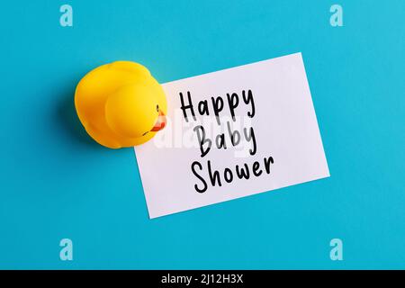 Message de douche de bébé heureux écrit sur un papier note avec un jouet en caoutchouc duckling. Fête de douche de bébé ou annonce de salutation. Banque D'Images