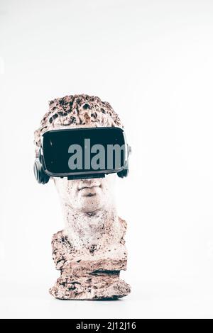 Statue ancienne avec lunettes VR sur fond blanc. Concept d'art et réalité virtuelle. Banque D'Images