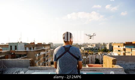 Jeune technicien homme volant UAV drone avec télécommande dans la ville Banque D'Images