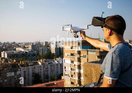 Jeune technicien homme volant UAV drone avec télécommande dans la ville Banque D'Images