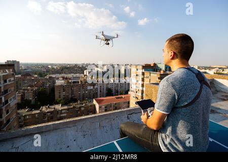 Jeune technicien homme volant UAV drone avec télécommande dans la ville Banque D'Images