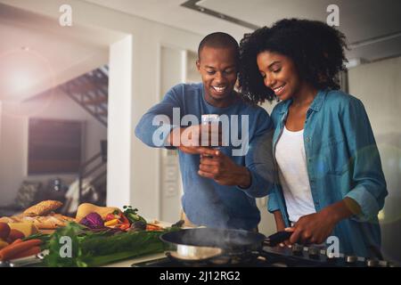 Un peu de poivre va beaucoup. Photo d'un jeune couple joyeux prenant une photo des ingrédients du repas qu'ils sont sur le point de préparer ensemble à la maison. Banque D'Images