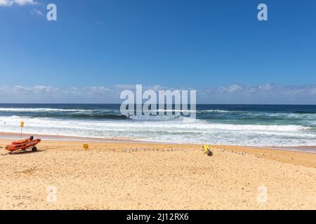 South Curl Curl plage à Sydney avec ciel bleu automne météo et surf sauvetage bateau zodiaque rouge sur la plage, NSW, Australie Banque D'Images