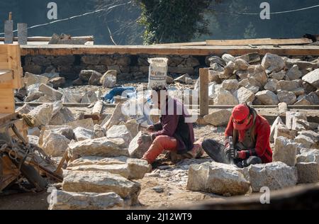 Lukla, Népal - 12 mars 2022 : deux hommes sculptant des pierres avec des burins et des marteaux au Népal. Banque D'Images