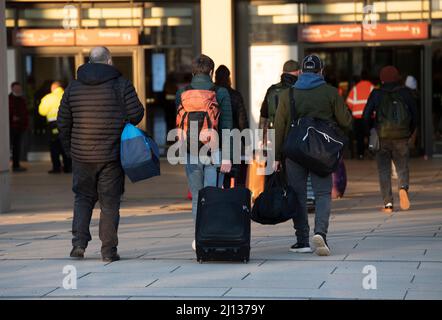 Berlin, Allemagne. 22nd mars 2022. Les voyageurs se rendent à pied au terminal de BER. Le personnel de sécurité de l'aéroport est en grève, ce qui ne prendra fin qu'à minuit. Dans la négociation collective avec l'Association fédérale des compagnies de sécurité aérienne, le syndicat Verdi exige, entre autres choses, que le salaire horaire pour les services de sécurité soit augmenté d'au moins un euro par heure et que les salaires soient alignés au niveau régional. Credit: Paul Zinken/dpa/Alay Live News Banque D'Images