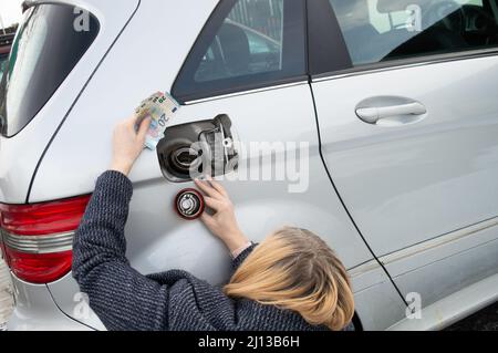 Femme préparant de l'argent pour remplir le réservoir. Concept d'augmentation du prix du gaz Banque D'Images