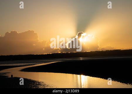 Un coucher de soleil d'hiver doré à Red Wharf Bay. La marée basse à la plage de Llandonna expose une grande zone de vasières, de marais salants et de plages de sable Banque D'Images