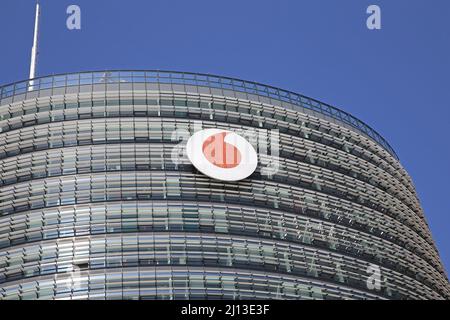 Düsseldorf (campus de Vodafone) - Mars 9. 2022: Gros plan du haut de la tour avec logo rouge de la compagnie de télécommunication contre ciel bleu clair Banque D'Images