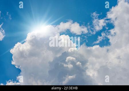 Beau ciel bleu avec des cumulus blancs et des rayons de soleil (rayons de soleil).Photographie en contre-jour. Banque D'Images