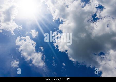 Beau ciel bleu avec des cumulus blancs et des rayons de soleil (rayons de soleil).Photographie en contre-jour. Banque D'Images