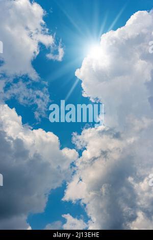 Beau ciel bleu avec des cumulus blancs et des rayons de soleil (rayons de soleil).Photographie en contre-jour. Banque D'Images