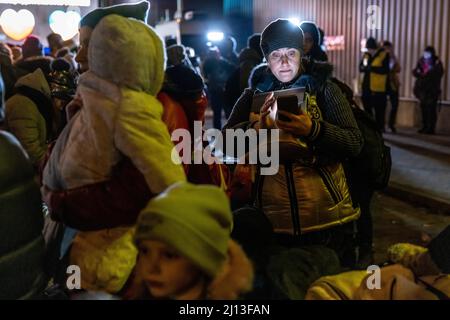Les réfugiés d'Ukraine ont atteint le point central de collecte des réfugiés dans un centre logistique près de Korczowa, dans la zone frontalière entre la Pologne et l'Ukraine. Ici, ils sont fournis avec de la nourriture et des vêtements et ensuite transportés en bus vers d'autres villes. Banque D'Images