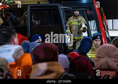 Les réfugiés d'Ukraine ont atteint le point central de collecte des réfugiés dans un centre logistique près de Korczowa, dans la zone frontalière entre la Pologne et l'Ukraine. Ici, ils sont fournis avec de la nourriture et des vêtements et ensuite transportés en bus vers d'autres villes. Banque D'Images