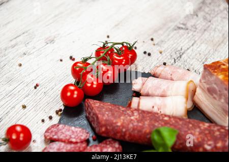 Saucisse fumée, viande, bacon au basilic et tomates cerises Banque D'Images