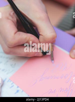 Processus de calligraphie écriture avec une plume de plume de plume d'encre, calligraphe pratiquant l'écriture sur papier de carte postale à l'aide de stylo brosse et de stylo de signe wi Banque D'Images
