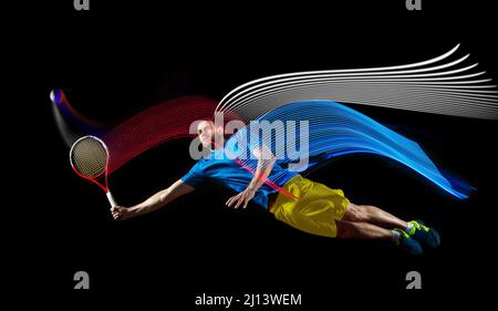 Portrait d'un jeune homme jouant au tennis isolé sur fond sombre avec des stipes de couleurs mélangées. Concept de sport, passe-temps, défis, paix, politique Banque D'Images