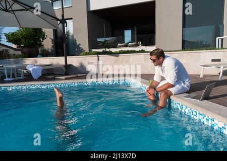 Une famille heureuse profite de vacances dans une maison de luxe avec piscine. Le père passe du temps avec son fils pour s'amuser dans la piscine. Mise au point sélective Banque D'Images