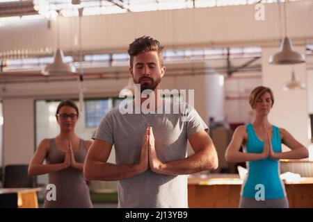 Trouver la paix intérieure. Un groupe de personnes faisant du yoga ensemble. Banque D'Images