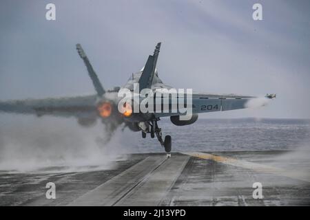 Mer des Philippines, États-Unis. 20 mars 2022. Un avion de chasse F/A-18E Super Hornet de la Marine américaine, affecté au chasseur 14 de l'escadron de chasse Tophatters of Strike, sort du pont de vol du porte-avions USS Abraham Lincoln de la classe Nimitz lors des opérations de routine, le 18 mars 2022, en mer des Philippines. Crédit : MC3 Javier Reyes/Planetpix/Alay Live News Banque D'Images