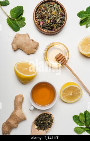 Vue de dessus sur le miel, la tasse de thé et la menthe sur fond blanc Banque D'Images