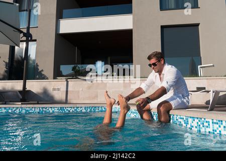 Une famille heureuse profite de vacances dans une maison de luxe avec piscine. Le père passe du temps avec son fils pour s'amuser dans la piscine. Mise au point sélective Banque D'Images