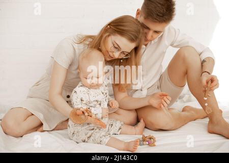 Jeune famille passant du temps ensemble, mère père bébé, jouer des jouets. Trouble déficitaire de l'attention. Se serrer et s'occuper Banque D'Images