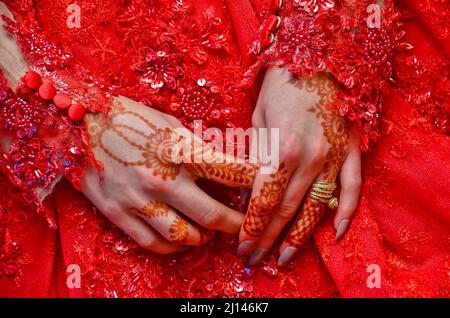 Gros plan de la main de la mariée avec le henné floral avec l'anneau de mariage. Banque D'Images