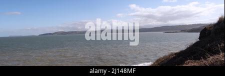 La vue à High Tide depuis les falaises de Red Wharf Bay, qui donne sur Llandonna. Au loin se trouve le Grand Orme et Snowdonia forme une toile de fond Banque D'Images