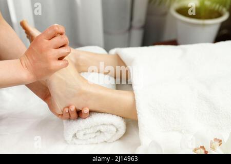 Femme spécialisée masseuse massant des pieds à une femme cliente dans un salon de spa, soins de beauté et concept de mode de vie de santé. Banque D'Images