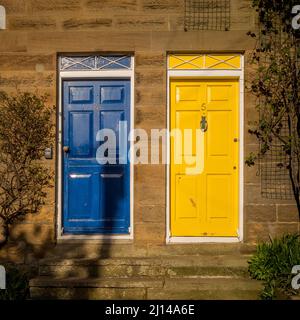 Les portes de cottages bleu et jaune sont situées sur Sunny place, une ruelle raide et étroite dans Robin Hoods Bay, North Yorkshire. Banque D'Images