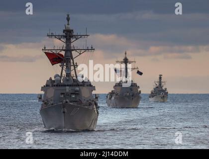 Océan Atlantique, États-Unis. 16 mars 2022. Les destroyers de la classe Arleigh-burke de la Marine américaine USS Paul Ignatius, à gauche, USS Nitze et la frégate de la classe Duke de la Royal Navy HMS Portland, à droite, naviguent en formation au coucher du soleil, le 15 mars 2022 dans l'océan Atlantique. Crédit : MC1 Eric Coffer/Planetpix/Alay Live News Banque D'Images