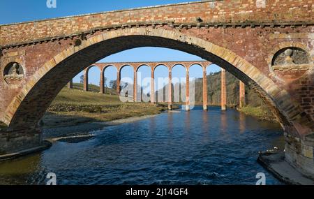 Vue sur le viaduc Leaderfoot au-dessus de la rivière Tweed encadrée par le vieux pont de Drygrange. Banque D'Images