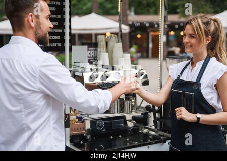 Belle femme Barista vendant du café au client Banque D'Images