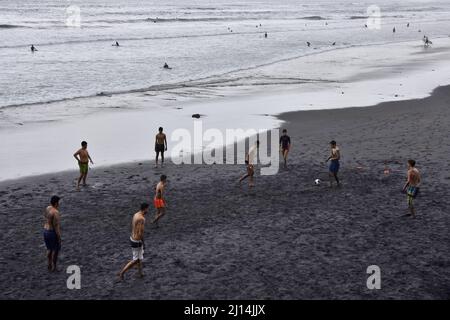 Jeunes hommes jouant au football sur le sable noir de la plage de Las Canteras situé à Las Palmas de la Grande Canarie îles Canaries Espagne. Banque D'Images