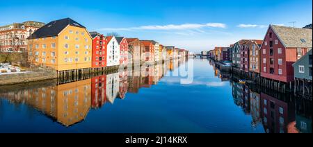 Vue panoramique sur les vieilles maisons en bois colorées avec des reflets sur la rivière Nidelva dans le quartier de Brygge à Trondheim, Norvège Banque D'Images