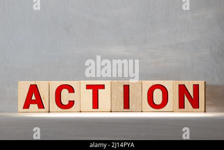 Un seul mot d'action sur un bloc de bois avec un fond bokeh bleu vintage doux. Planification et stratégie d'affaires. Des idées innovantes. Plan d'action. Agissez Banque D'Images