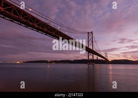 Le pont 25 de Abril (Ponte 25 de Abril) traversant le Tage (Rio Tejo) au crépuscule, et le Cristo de Rei - Lisbonne, Portugal Banque D'Images