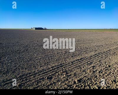 Ciel bleu au-dessus des champs avec ferme à la distance Banque D'Images