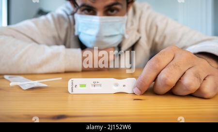 L'homme caucasien fabrique un appareil de test rapide à domicile pour le virus Covid19 avec un résultat négatif. Cassette d'antigène de test PCR express pour la nouvelle variante d'Omicron vi Banque D'Images